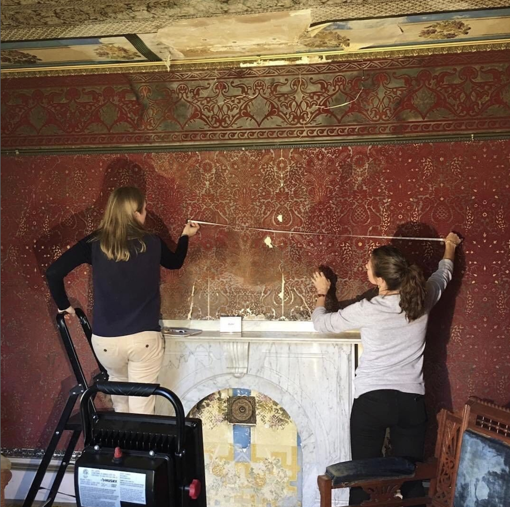 Conservators working on wallpaper in the parlor/NPS