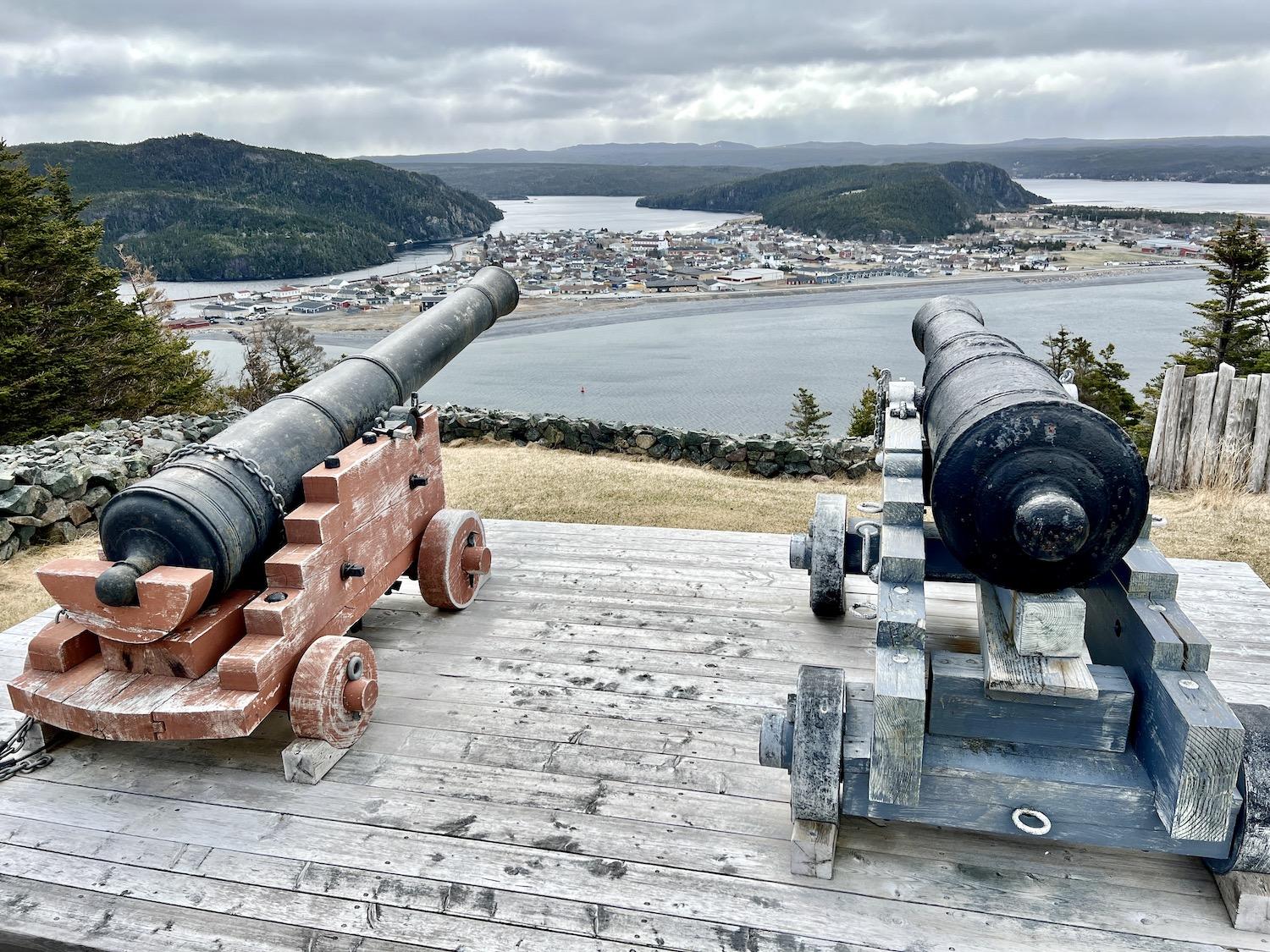 A view of modern-day Placentia through cannons at Castle Hill National Historic Site.