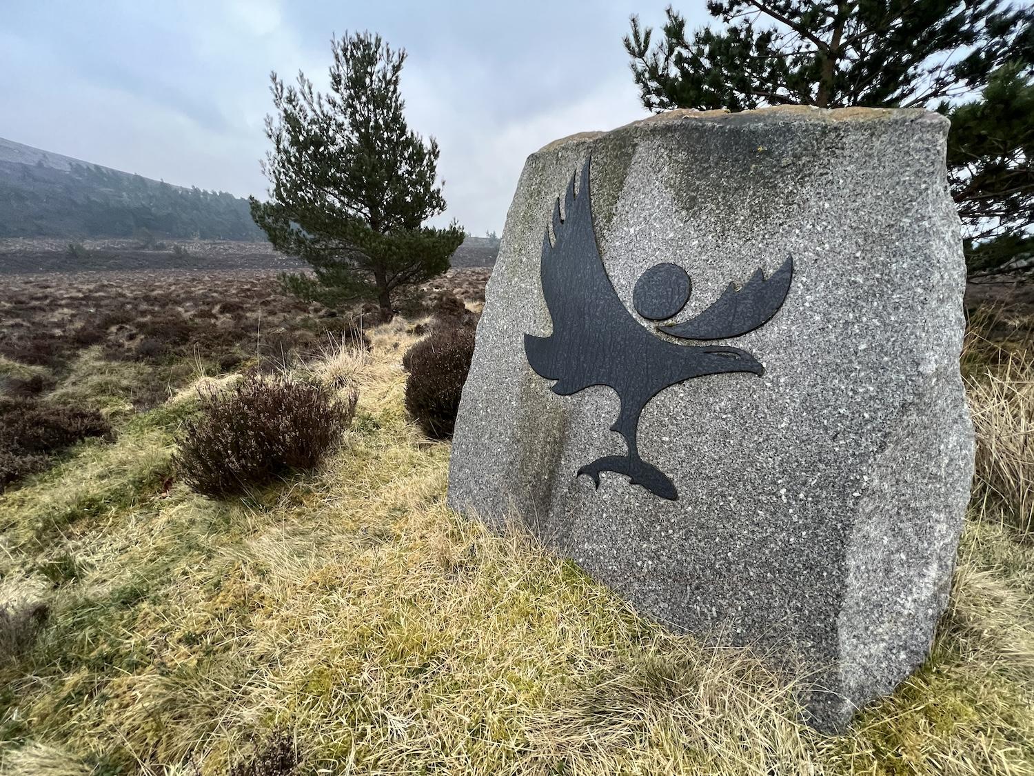 A stone showing an osprey and fish marks the border of Cairngorms National Park in Scotland.