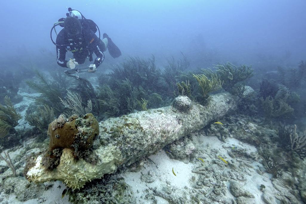 A National Park Service diver documents one of five coral-encrusted cannons found during a recent archeological survey in Dry Tortugas National Park/NPS, Brett Seymour