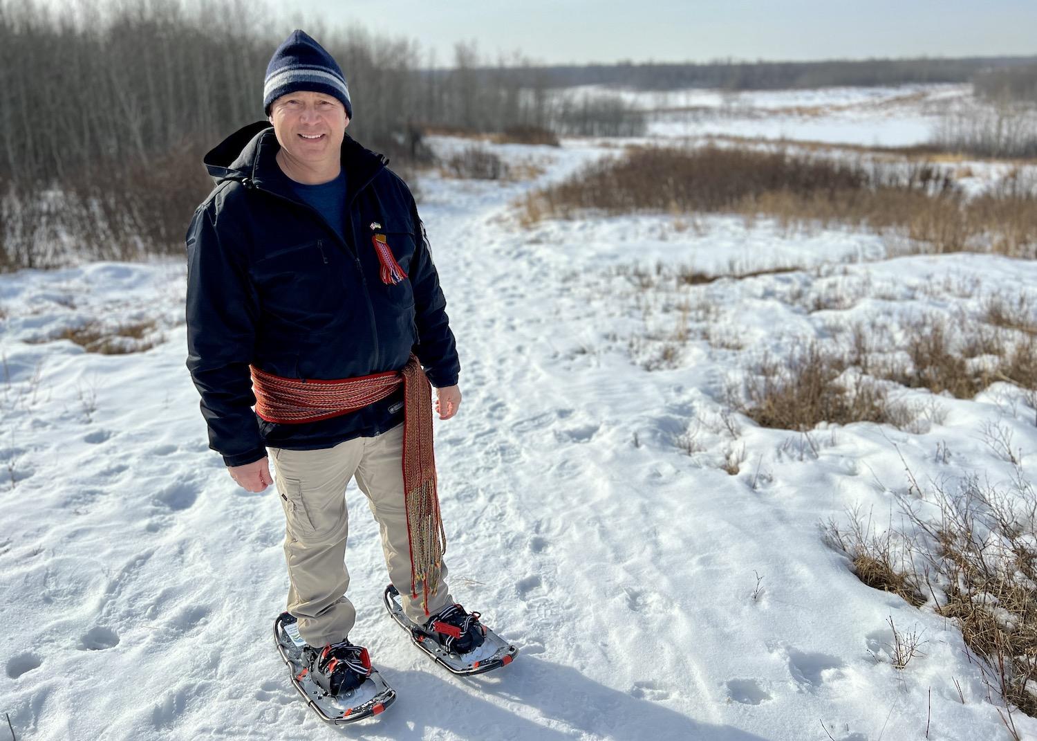 Keith Diakiw, a Métis geologist who founded Talking Rock Tours, leads a guided snowshoe trip through Elk Island National Park in Alberta wearing a Métis sash.