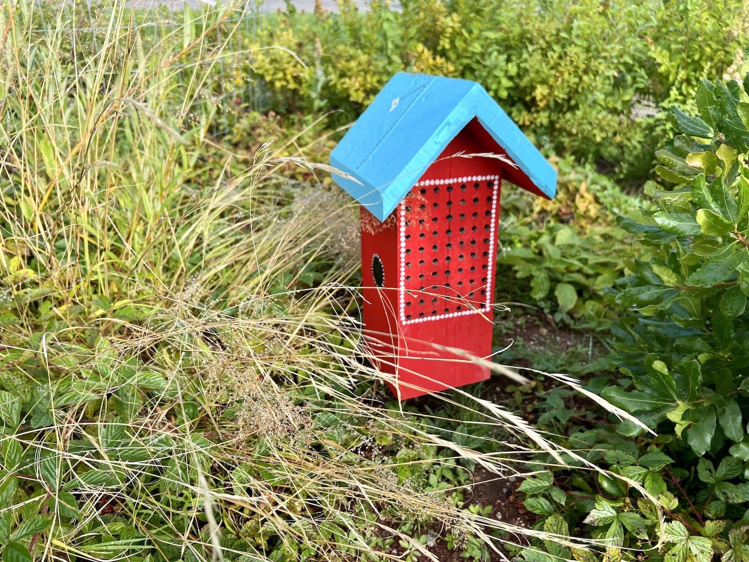 A brightly painted bee house adds eye appeal to Fundy's pollinator garden.