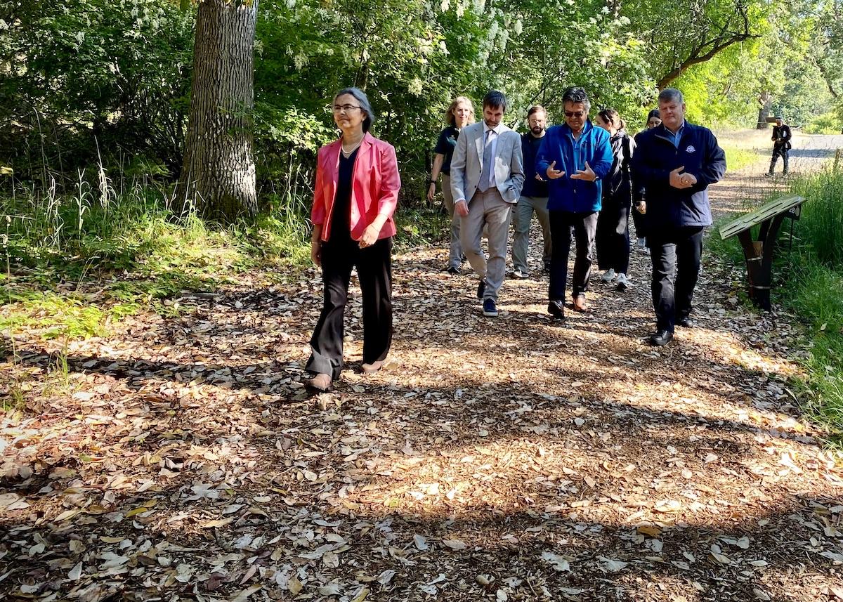 Nitya Chari Harris from the steering committee of Indigenous-led West Coast Stewardship Corridor, walks through Fort Rodd Hill and Fisgard Lighthouse National Historic Sites during a funding announcement with other officials.