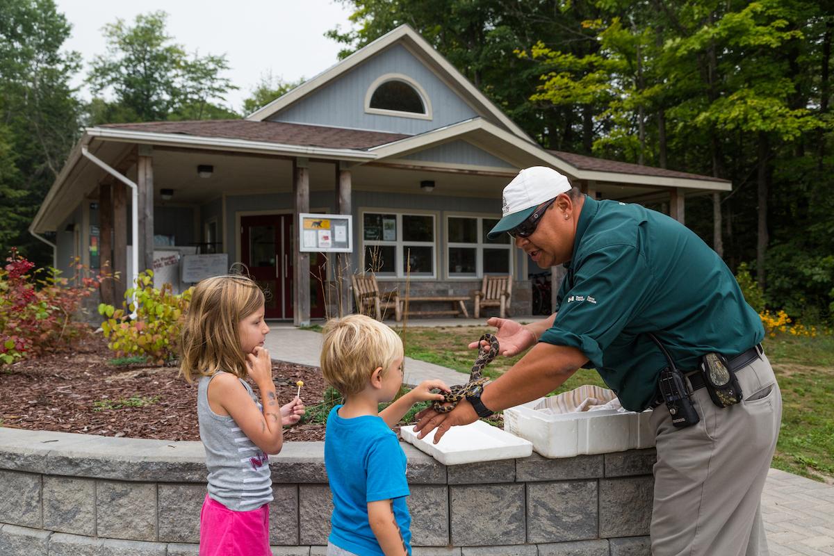 Introducing young visitors to a snake (before Covid) on Beausoleil Island at Georgian Bay Islands National Park.