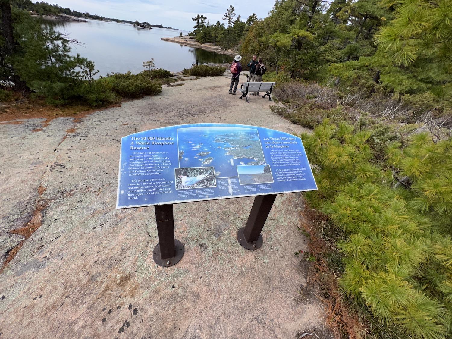 Parks Canada interpretation coordinator Mike Lavin chats with hikers on the rocky shore of the north end of Beausoleil Island.