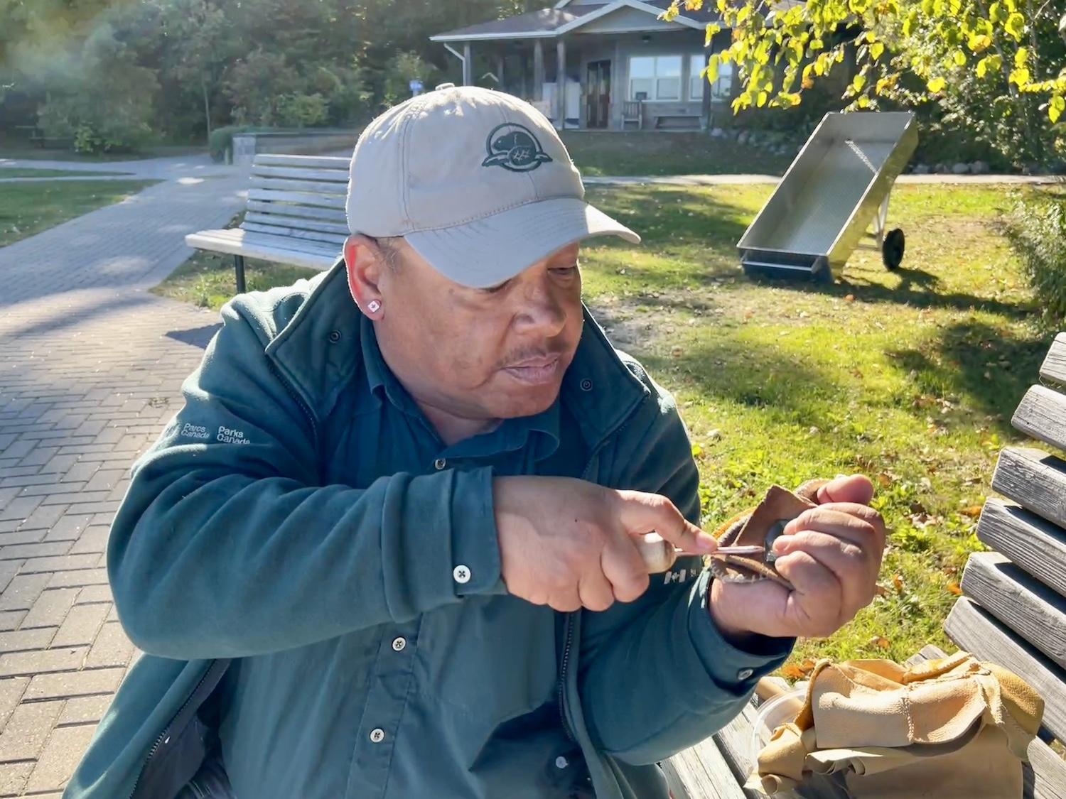 Indigenous liaison officer Shawn Corbiere demonstrates flint knapping.