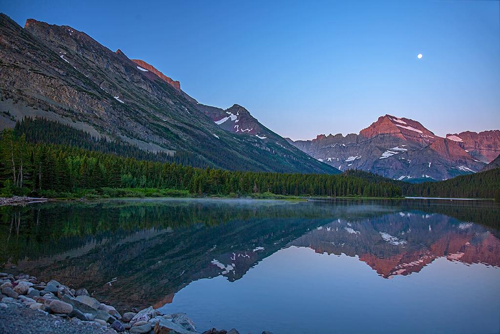 The beginning of sunrise over Mounts Gould and Grinnell at Swiftcurrent Lake, ISO 125, f/4, 1/13 second, Many Glacier Area, Glacier National Park / Rebecca Latson