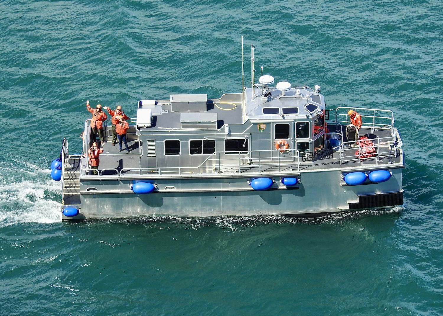 From the M/V Serac, Glacier Bay rangers wave goodbye to the cruise ship they just spent a day on. From the M/V Serac, Glacier Bay rangers wave goodbye to the cruise ship they just spent a day on.