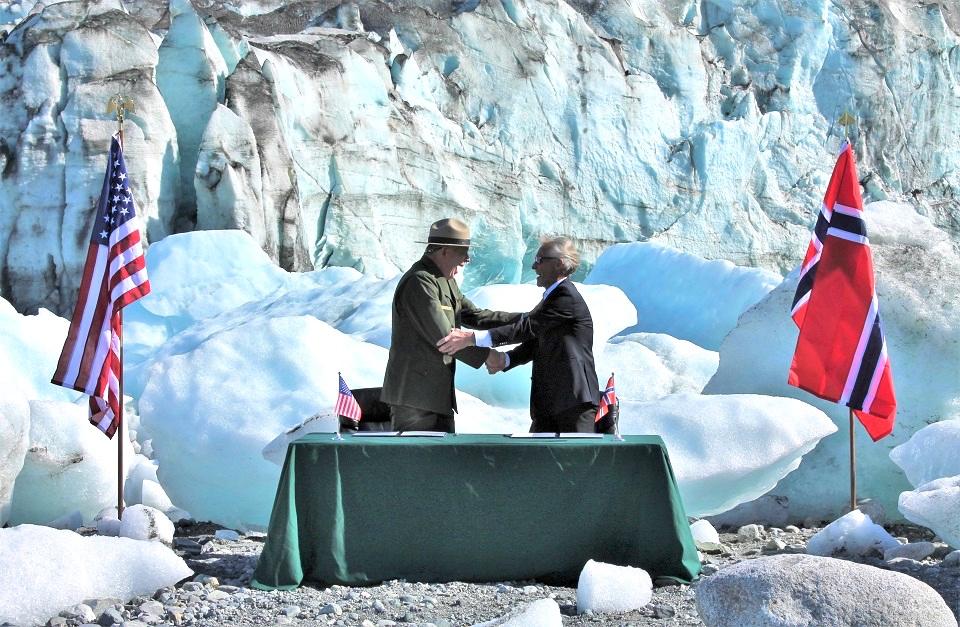 Superintendent Hooge and West Norwegian Fjords Board Chairman Arne Sandes shake hands after signing the agreement in front of the Lamplugh Glacier in Glacier Bay/NPS, S. Schaller