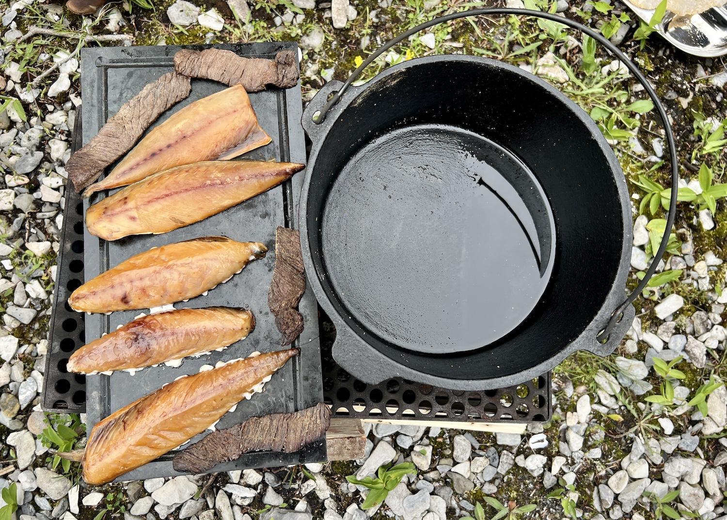On the Discover Mekapisk outing with Gros Morne Adventures, marinated moose and smoked mackerel are warmed up at a campfire on an isolated beach.