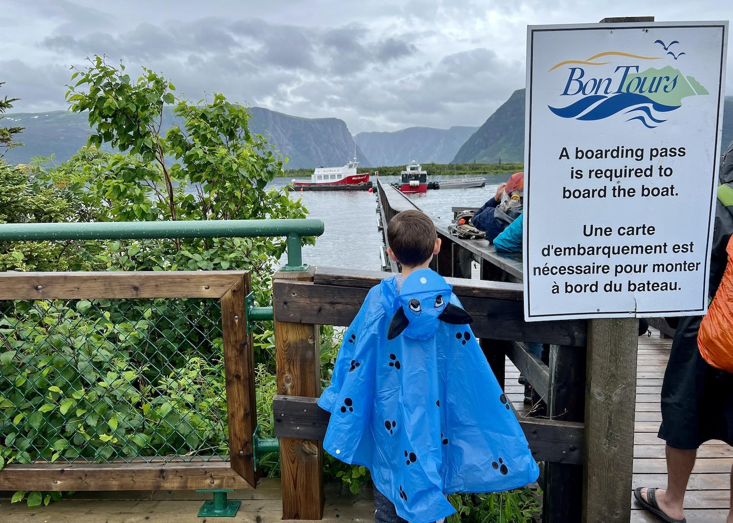 On a rainy day in July 2023, people wait for the signal to board a BonTours boat on Western Brook Pond for a guided tour.