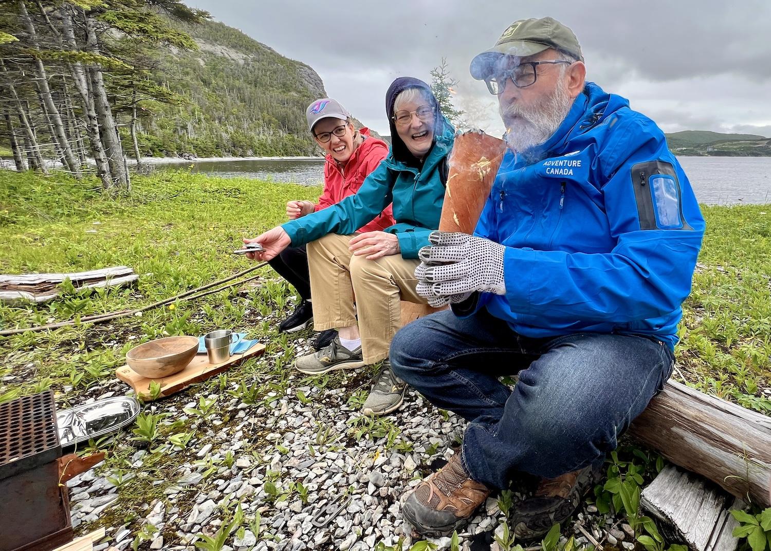 Rick MacKenzie blows on a flame lit inside a cone of birch bark.