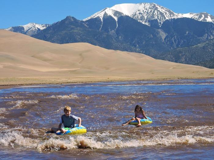 Kids tubing in Medano Creek at Great Sand Dunes National Park/NPS