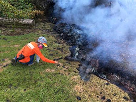 An HVO geologist collects spatter sample at fissure 10 near the intersection of Malama and Pomaikai Streets, Leilani subdivision
