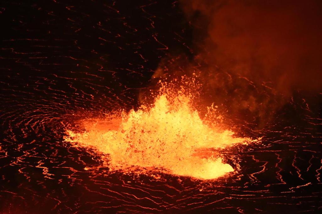 A telephoto image of one of the low lava fountains near the center of the growing Halema'uma'u lava lake. The ongoing eruption at the summit of Kīlauea is confined within Halema'uma'u, with numerous lava fountains producing lava and volcanic gases. Hawaii