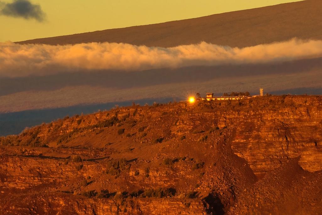 Sunrise is reflected in the windows of the NPS and USGS buildings that will be deconstructed and removed at Uēkahuna bluff at the summit of Kīlauea volcano in Hawaiʻi Volcanoes National Park  in the weeks ahead/NPS, J. Wei