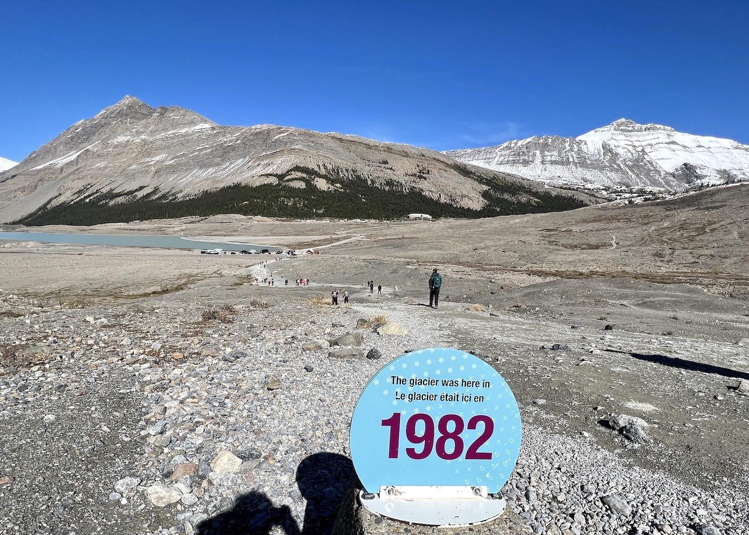 A sombre reminder of how climate change has impacted the Athabasca Glacier, with a view of the parking lot and, across the highway, the Icefields Centre.