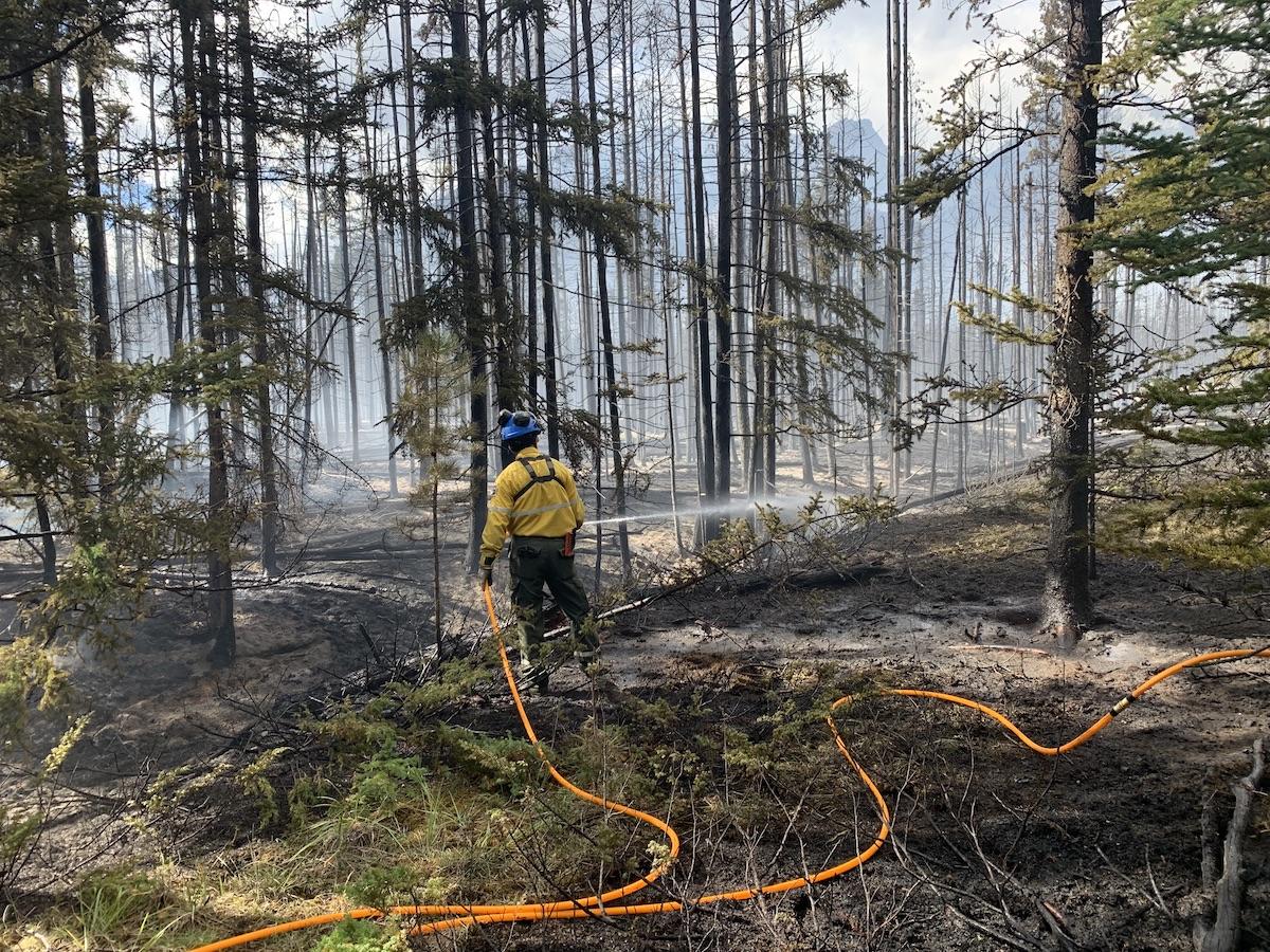 In this undated file photo of the Chetamon wildfire, a firefighter uses a hose.