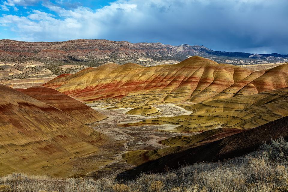 Late afternoon storm clouds and sunlight over the Painted Hills Unit, John Day Fossil Beds National Monument / Rebecca Latson