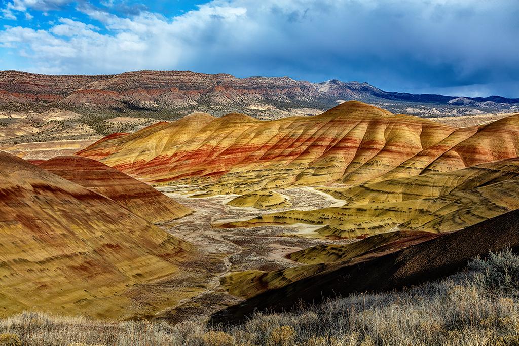 Late-afternoon storm clouds and sunlight over the Painted Hills, Painted Hills Unit, John Day Fossil Beds National Monument / Rebecca Latson