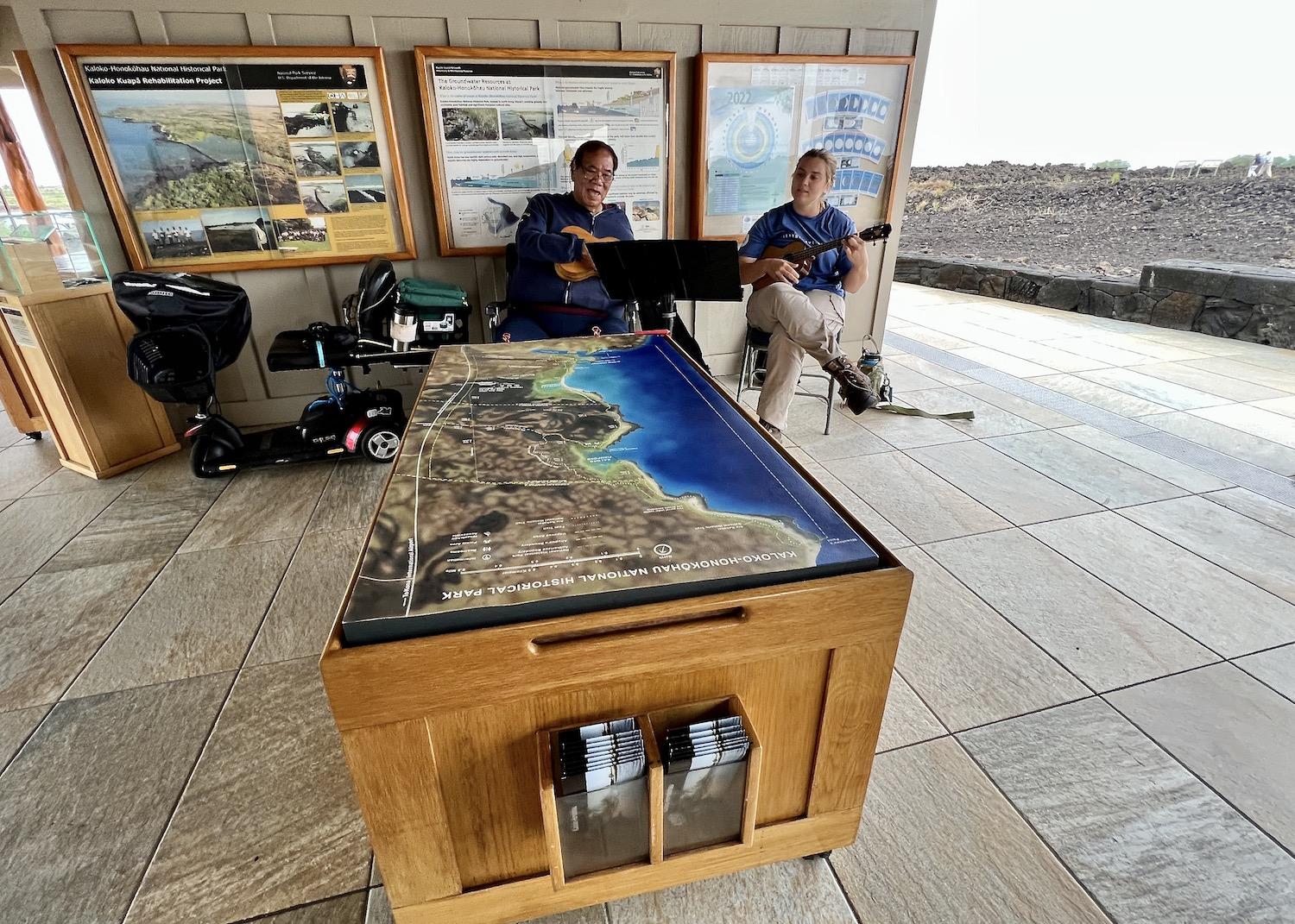 Volunteer Rance Pinao, left, plays ukulele in the visitor contact station.
