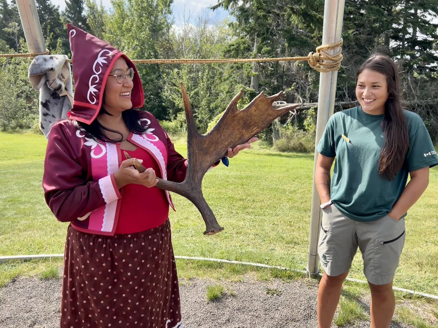 During a Wigwam Gathering at Kouchibouguac National Park, interpretation officer Katrina Sock, left, talks about Mi'kmaq hunting while heritage presenter Hannah Ward looks on.