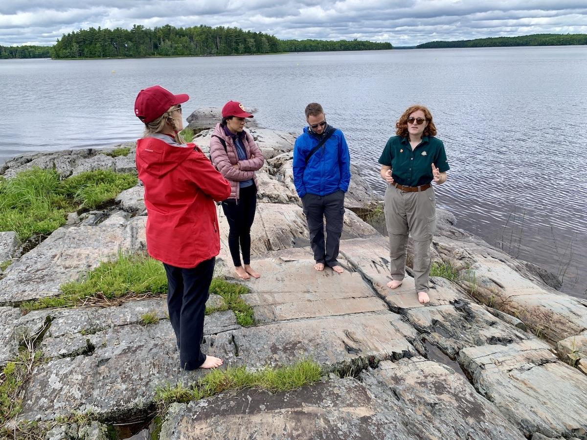Parks Canada interpreter Alex Hancock, right, guides travel writers to a Keji petroglyph site.