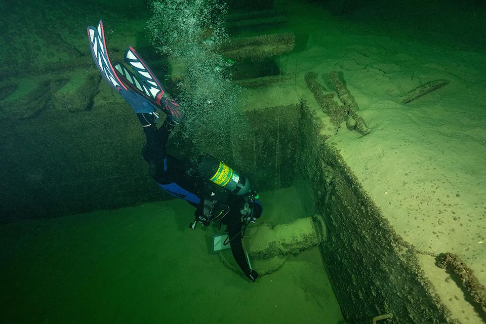 Brian Moeberg, a veteran who dives with the Waves Project, takes measurements of a sand storage bin at the submerged Boulder Basin Aggregate Classifications Plant, where gravel, cobble, and sand were sorted to mix the concrete used to build Hoover Dam in 
