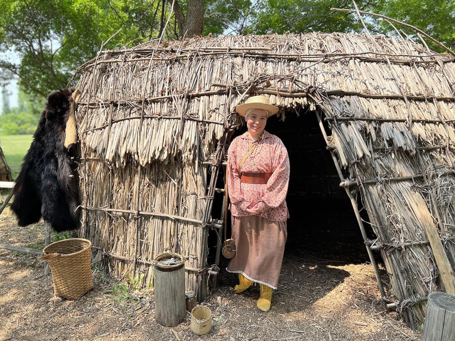 Parks Canada interpretation student Hannah Torchinsky stands at Gabeshiwin Camp at Lower Fort Garry.