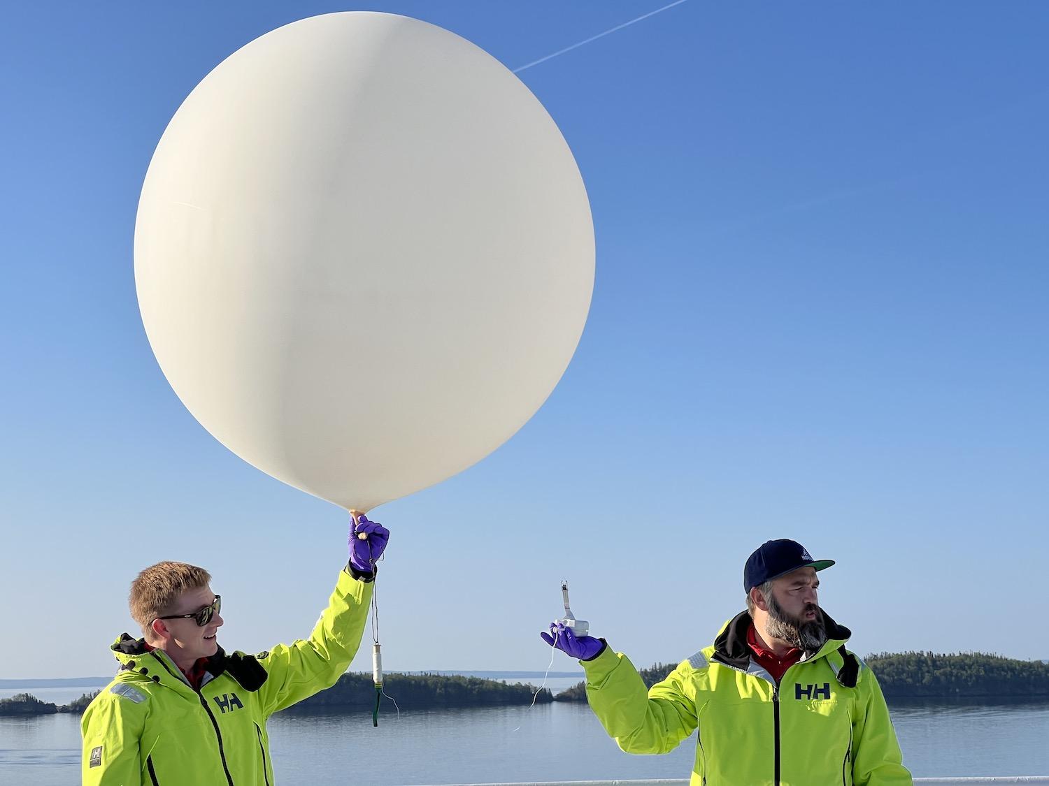 Field scientist Josh Pons, left, and general naturalist Martin Hans, release a weather balloon from the deck of the Viking Octantis while in Lake Superior in June.