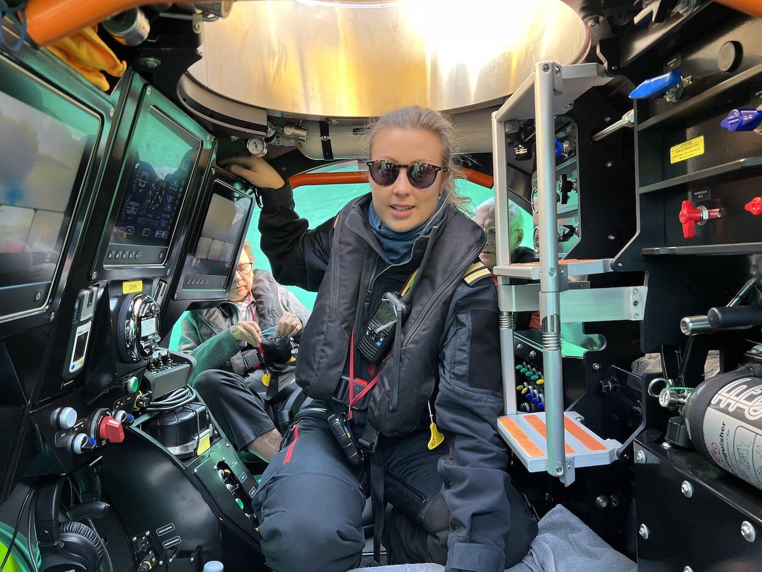 Viking submersible pilot Jessica Burnell sits in the center of "John" with three guests on either side of her control panels.