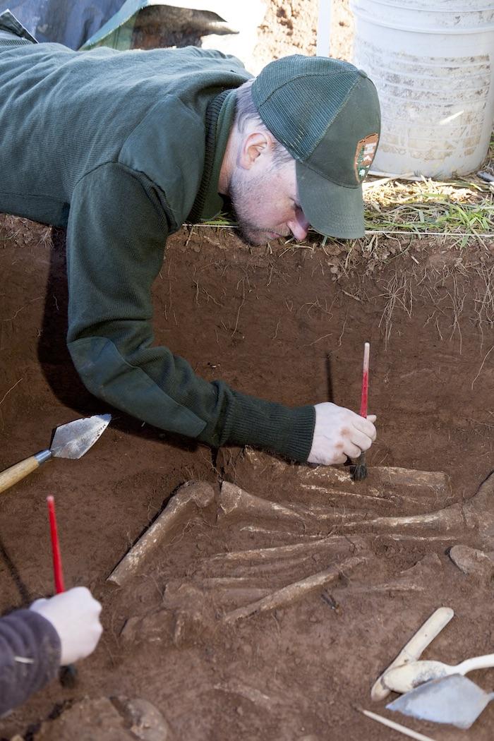 Manassas National Battlefield Park Superintendent Brandon Bies, then an archeologist, examines the remains of Civil War soldiers in a surgeon’s pit found at Manassas National Battlefield Park/Smithsonian INstitution