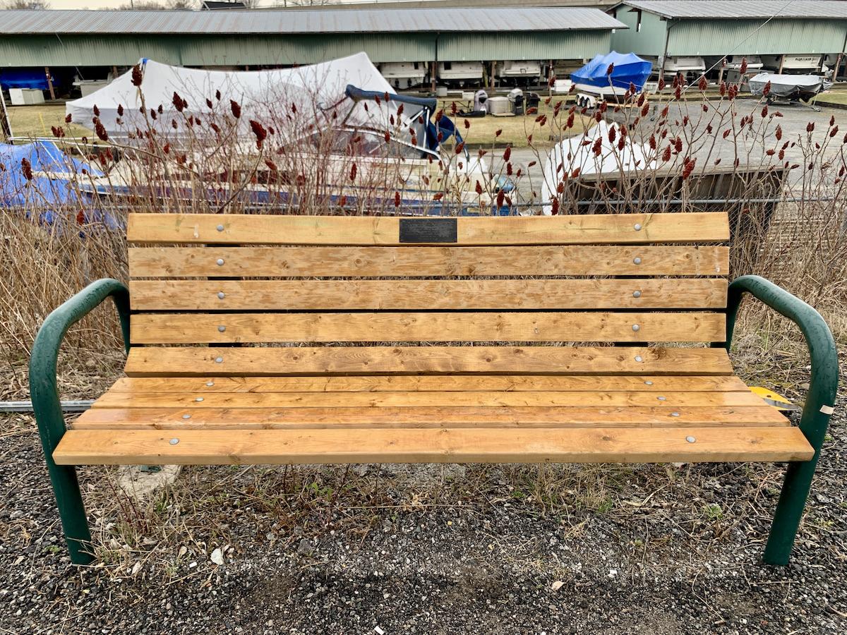 A bench near the trestle, wetlands and swing bridge has a message from the Mnjikaning Fish Fence Circle.
