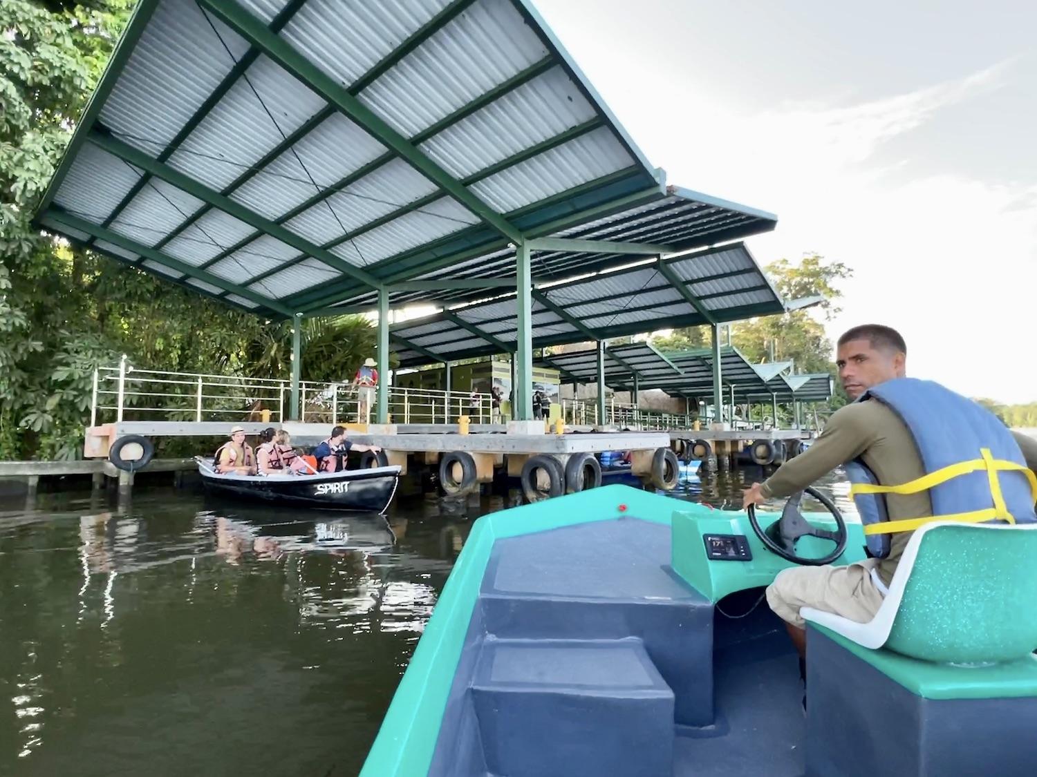 Boat driver/wildlife spotter Michael Bennet stops at the Tortuguero National Park ranger station to pay our fees and find out which canal we can visit.