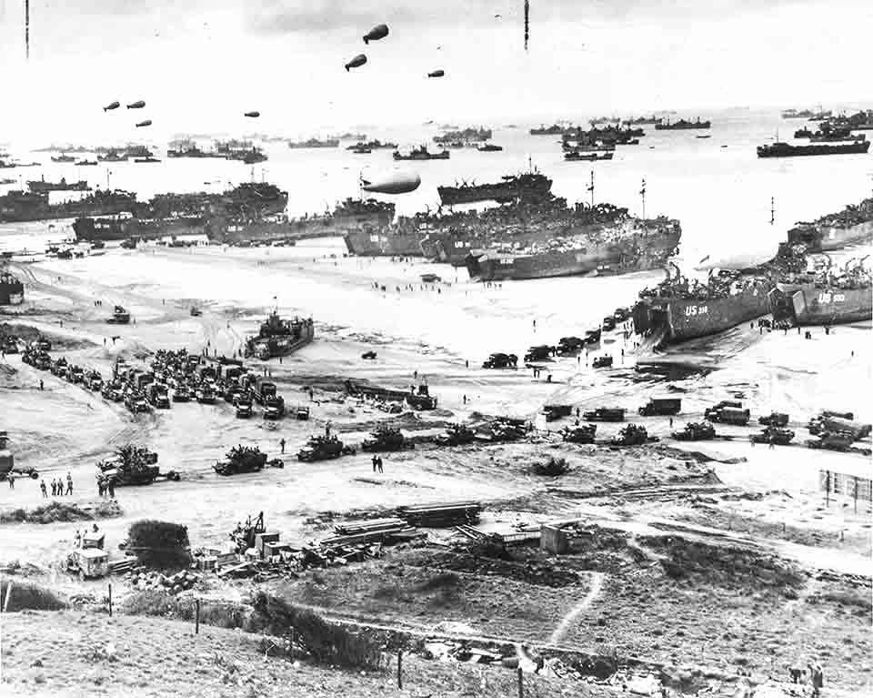 A very busy aerial picture of Normandy Beach, France in 1944 as dozens of Allied transport ships unload their cargoes of tanks, vehicles, and soldiers/Library of Congress