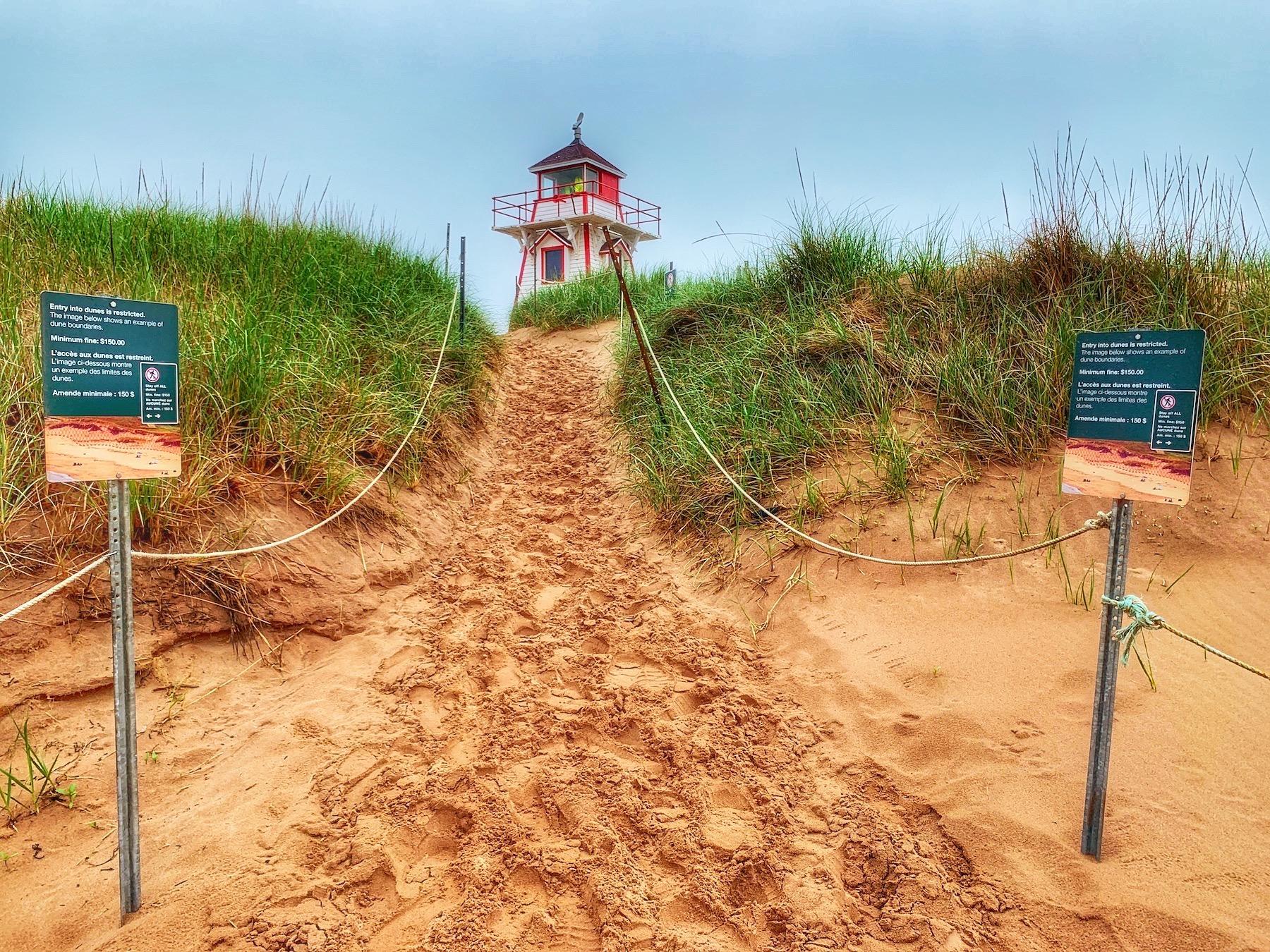 Visitors to Covehead Lighthouse at Prince Edward Island National Park are kept off the sand dunes on the path to the beach.