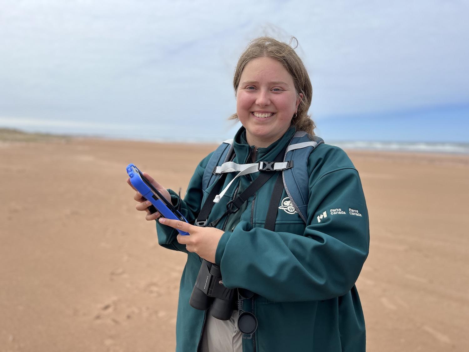Parks Canada resource management officer Lily McLaine fills out digital details about a Piping Plover nest in Prince Edward Island National Park.
