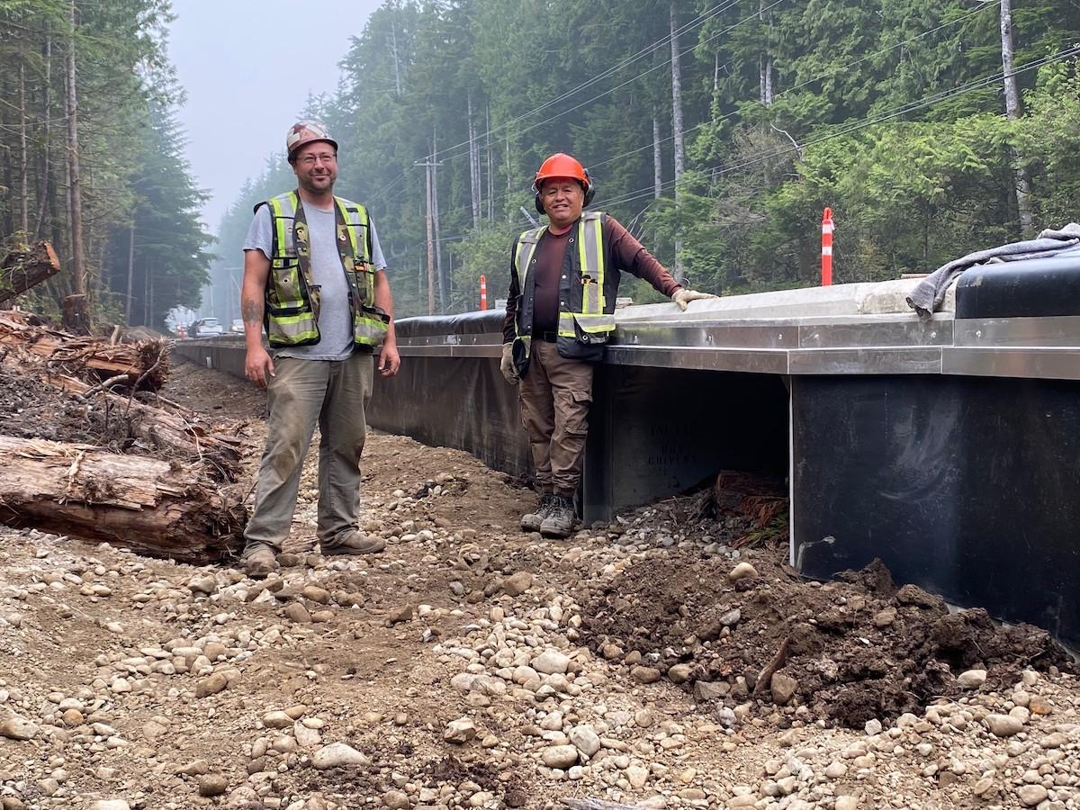 Two workers build an amphibian highway crossing.