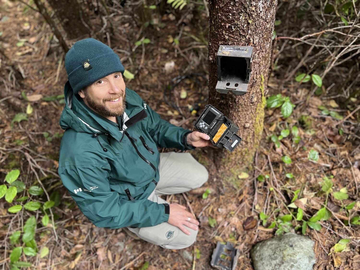 Parks Canada's Todd WIndle shows a wildlife camera that's being used to study wolves in Pacific Rim National Park Reserve.