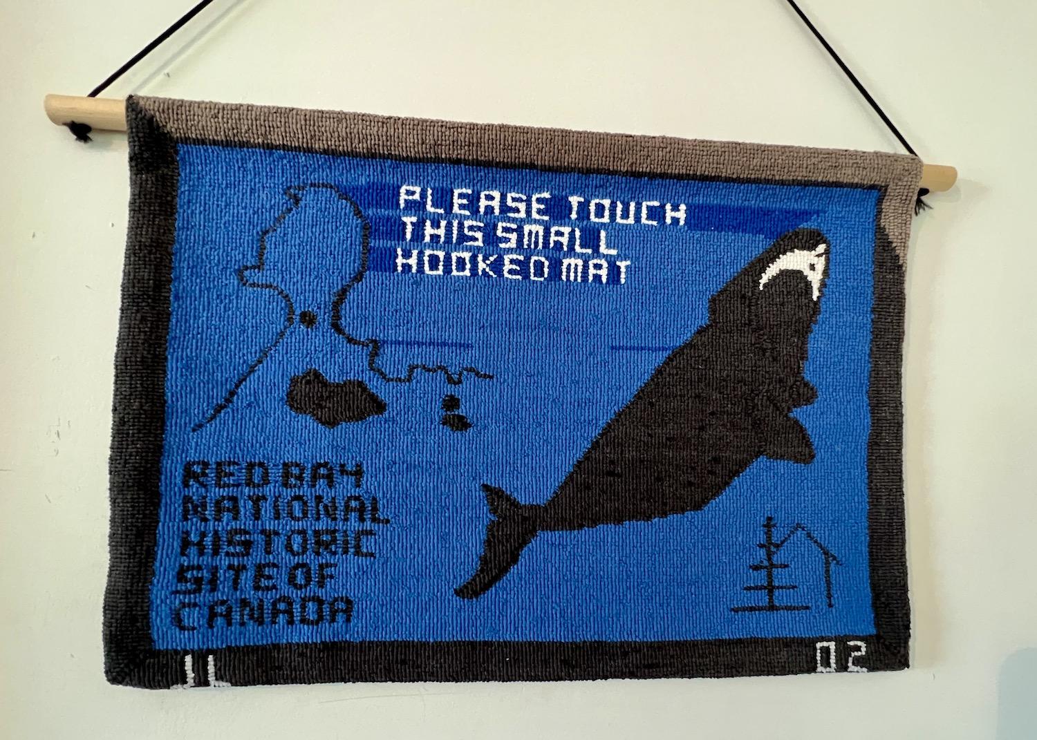 A hooked mat that shows a right whale is on display at the Red Bay National Historic Site.