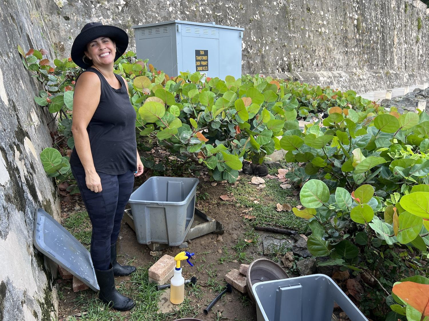 Karla Colom volunteers three times a week with Save A Gato, feeding and caring for the cats that live along a paved pathway on National Park Service land in San Juan.