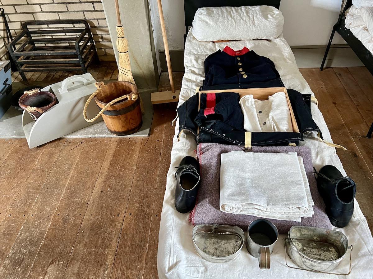 Inside the Queen's Battery Barracks, cots and clothes are laid out to view.