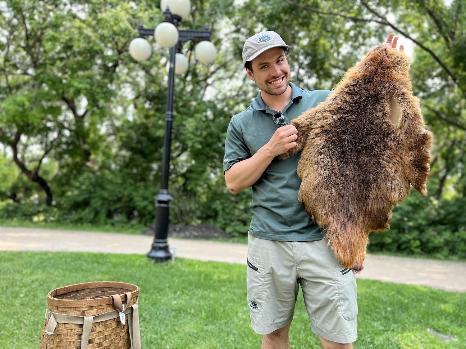 On a guided tour of the Forks National Historic Site, Ayden Schumacher shows off a beaver pelt that was so critical to the fur trade.