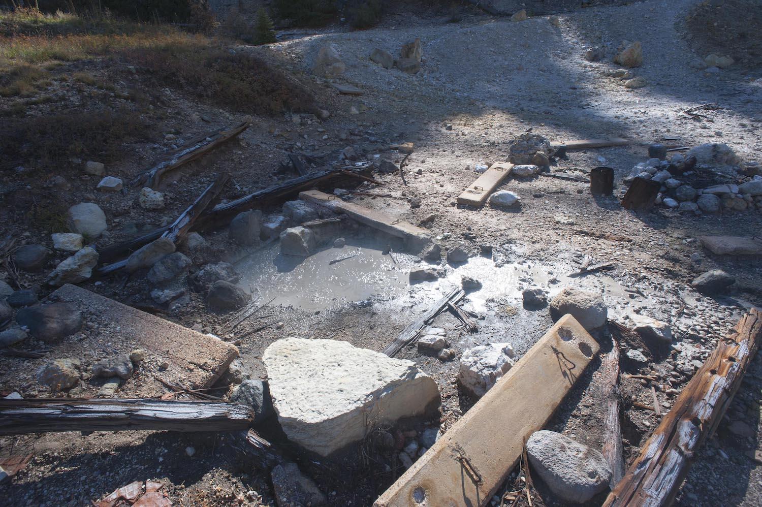 This debris, possibly related to a bathhouse, surrounds a bubbling mudpot/Patrick Cone