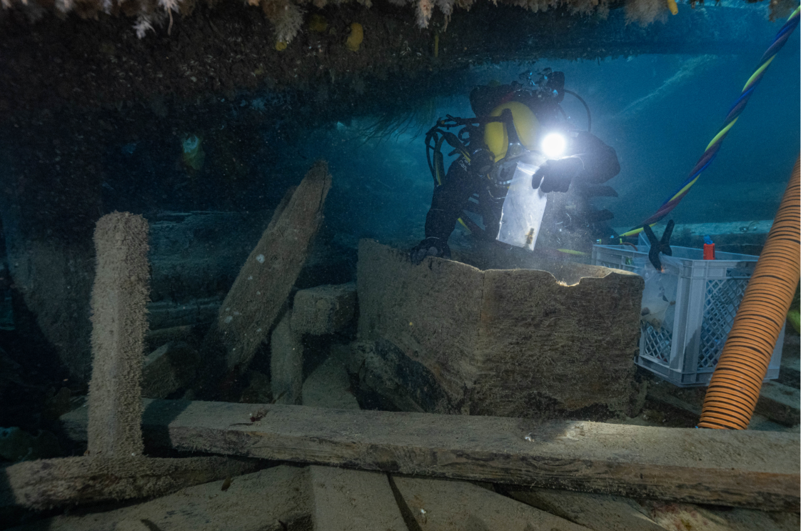 Parks Canada underwater archaeologist Marc-André Bernier excavates a seaman’s chest in the forecastle (crew living quarters) on the lower deck of HMS Erebus on Sept. 14, 2023. He holds a recovered medicinal vial in an artifact bag. 