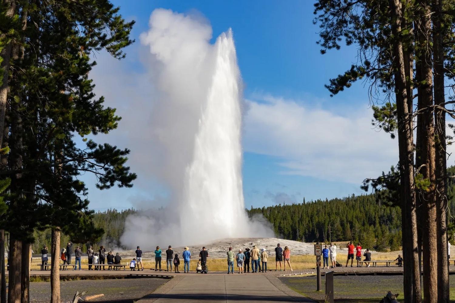 The Old Faithful geyser rockets up once again while a small crowd looks on in August 2022. (National Park Service/ Jacob W. Frank)