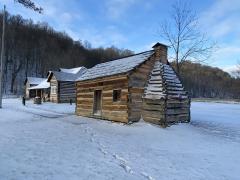 A larger tavern and smaller cabin in the snow, Abraham Lincoln Birthplace National Historical Park