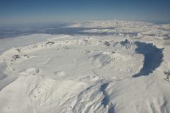 An arial panorama view of snow-covered Aniakchak Caldera in Aniakchak National Monument & Preserve in Alaska