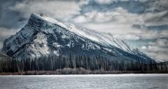 A winter view of snow-covered Mount Rundle towering over one of the Vermillion Lakes in Banff National Park, Canada