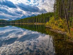 Mountains and clouds reflected in Herbert Lake's mirror-smooth water, Banff National Park